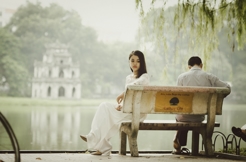 Couple Sitting Apart on a Bench, While the Woman Looks Out in the Distance