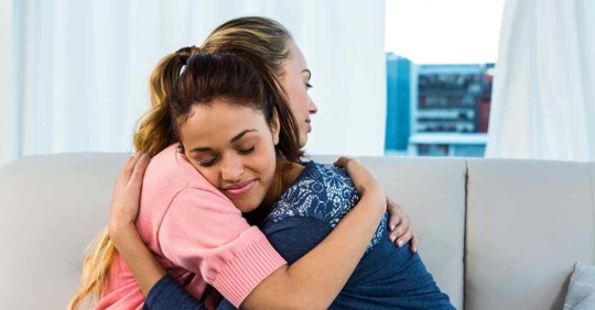 A woman hugging another woman in support