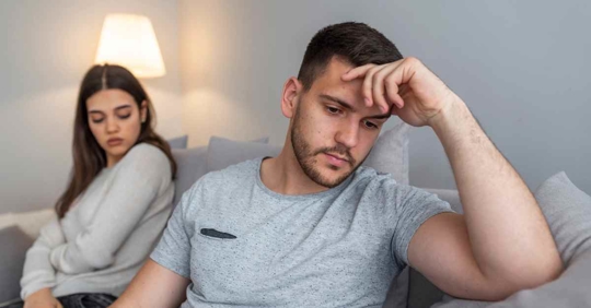 A man and woman sitting next to each other but looking away from each other