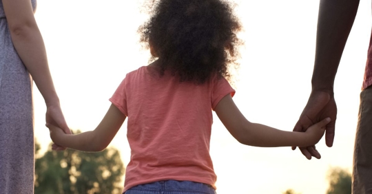 parents holding hands with child