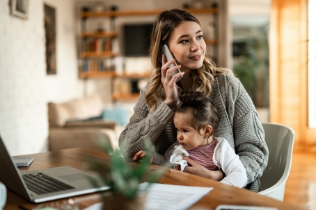 Woman on phone with attorney while holding child in lap