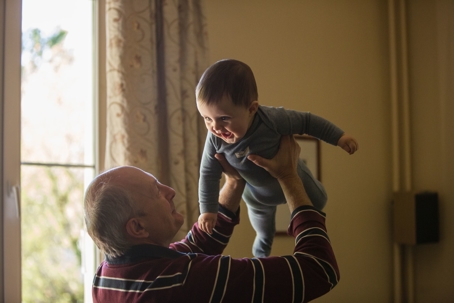 grandpa holding up grandson