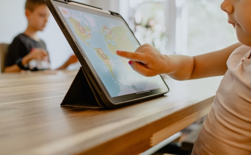 child on tablet at kitchen table