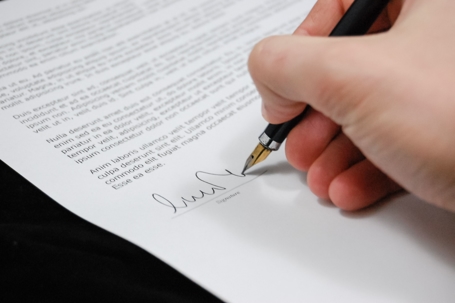Hand signing divorce paper.