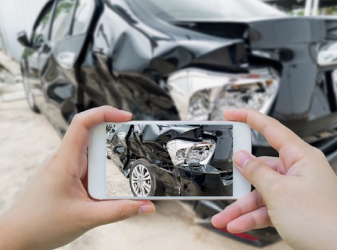 driver taking picture of car accident